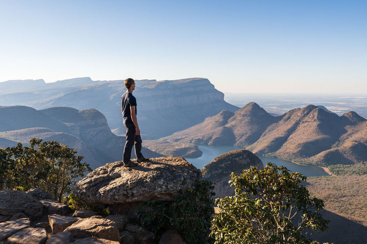 Man standing on mountain against clear blue sky