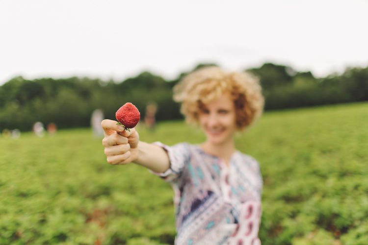 Woman showing a ripe strawberry