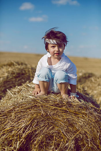 Young woman standing on hay