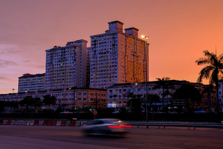 View of city street and buildings at dusk