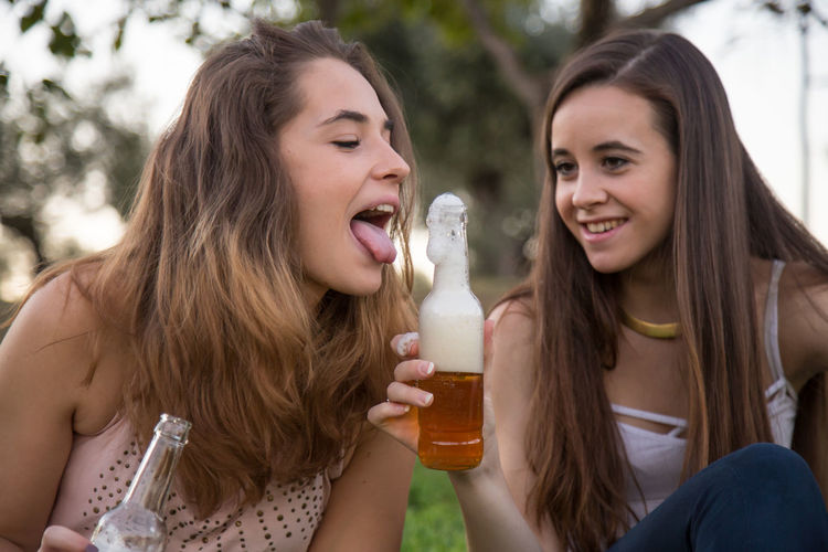 Portrait of happy friends holding beer bottle