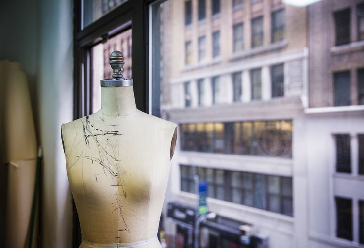 Dressmaker's model by glass window at design studio