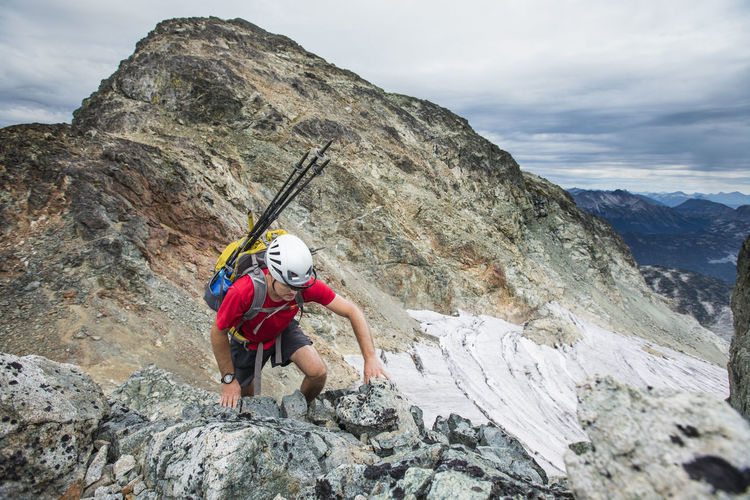 High angle view of backpacker climbing a rocky mountain.