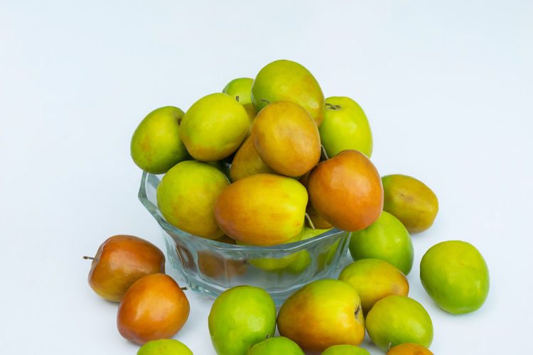 Close-up of apples in bowl against white background