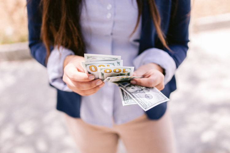 Midsection of woman holding banknotes