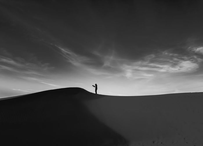 Low angle view of silhouette person standing against sky