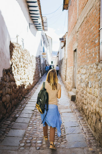 A young woman is walking down the street of the city of cusco, peru