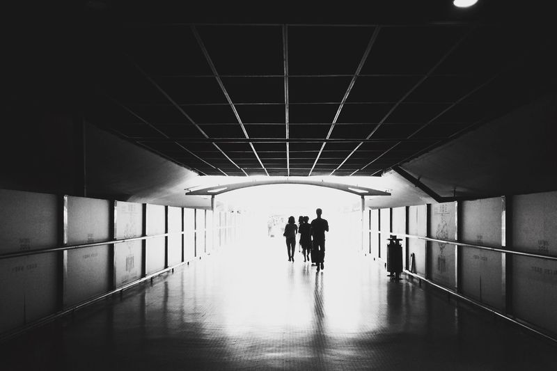 Silhouette of people walking in subway tunnel
