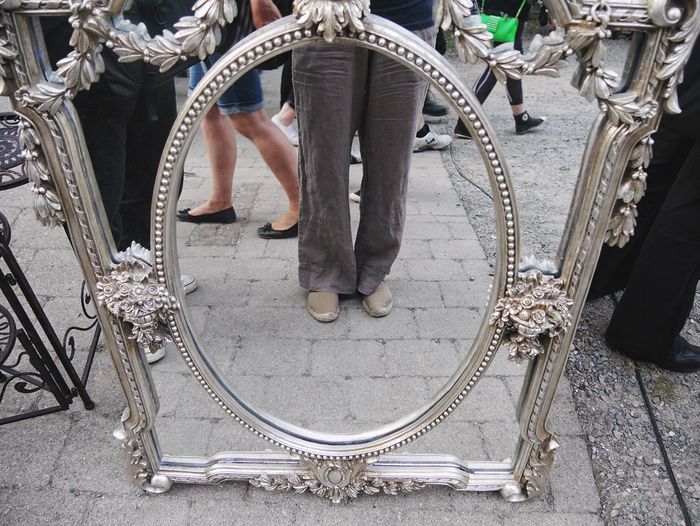 Low section of man standing behind mirror frame
