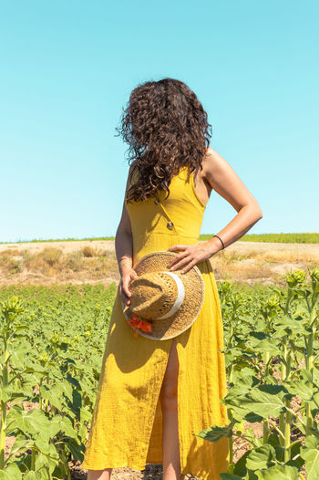 Full length of woman standing in sunflower field