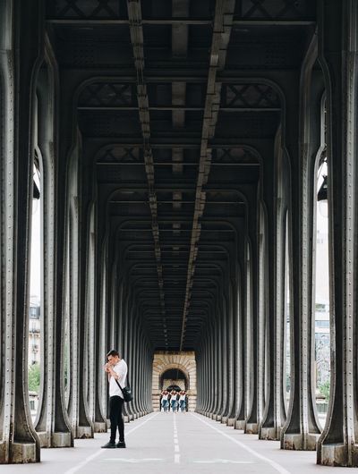 People walking under bridge