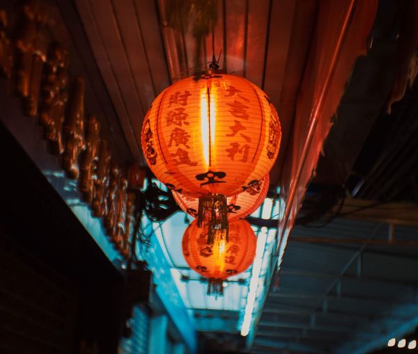 Low angle view of illuminated lanterns hanging on ceiling in building