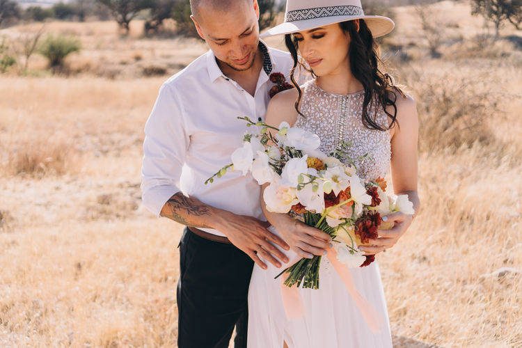 Midsection of couple standing on field