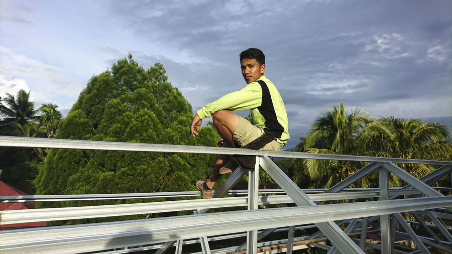 Full length of boy on railing against sky