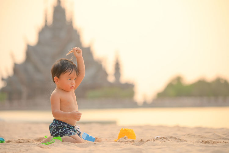 Full length of shirtless boy on beach