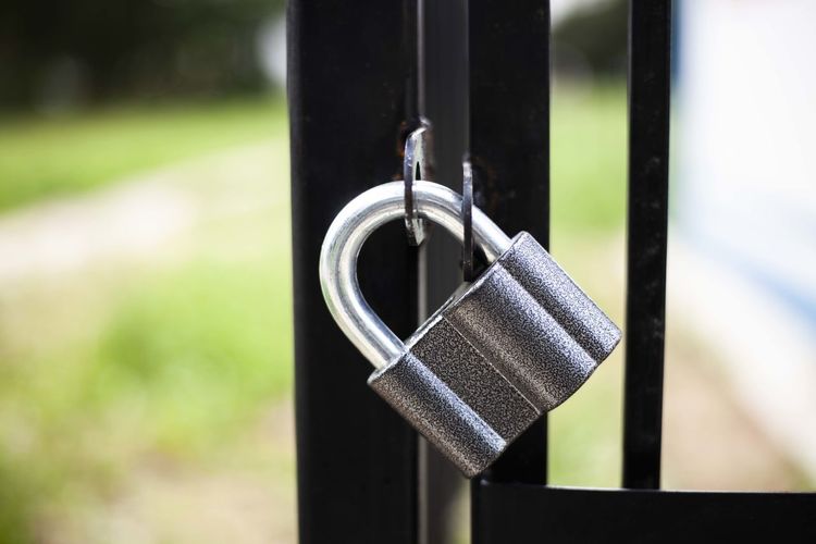 The castle locks the gate. a metal lock weighs on a fence. reliable property protection. 