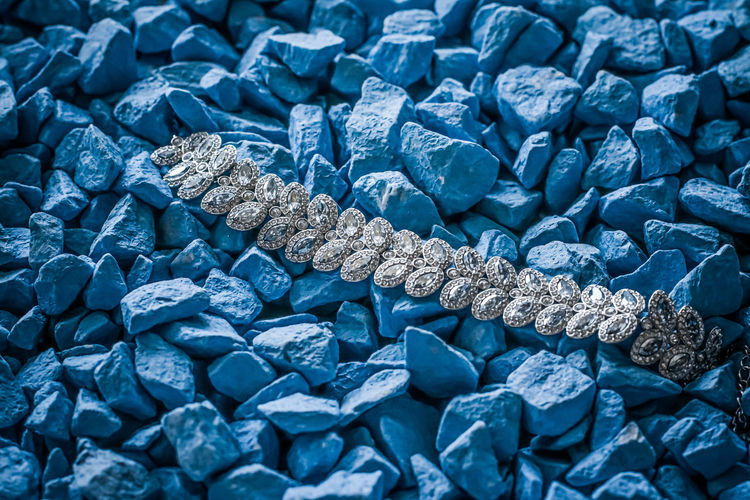 High angle view of diamond necklace on stones