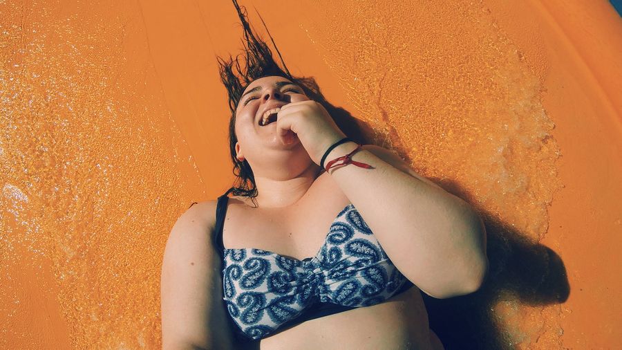 High angle view of happy woman enjoying water slide at park