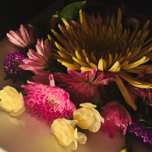Dramatic candlelit arrangement of flowers on a plate