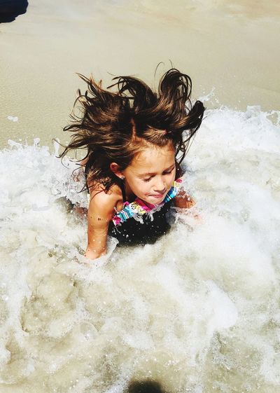 High angle view of girl playing in water at beach