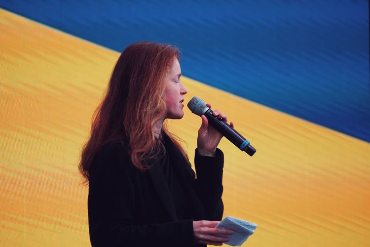 Close-up of woman standing in stage with ukraine flag 