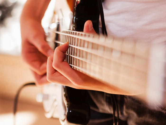 Close-up of person playing electric guitar