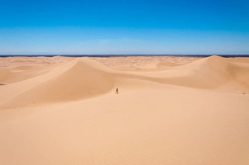 Teenage girl on desert against sky