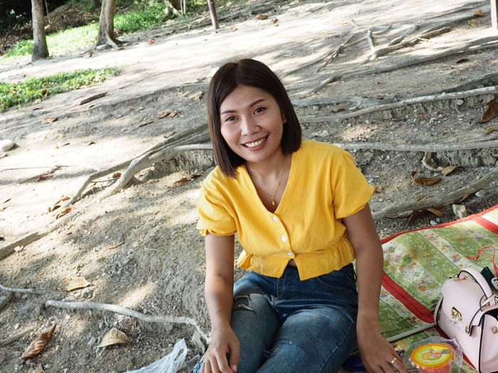 Smiling woman sitting on picnic blanket