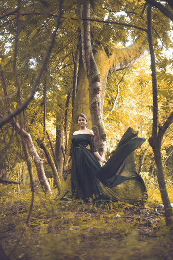Woman sitting on tree trunk in forest