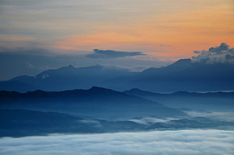 Scenic view of mountains against cloudy sky