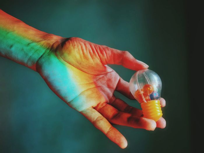 Close-up of hand holding plastic light bulb