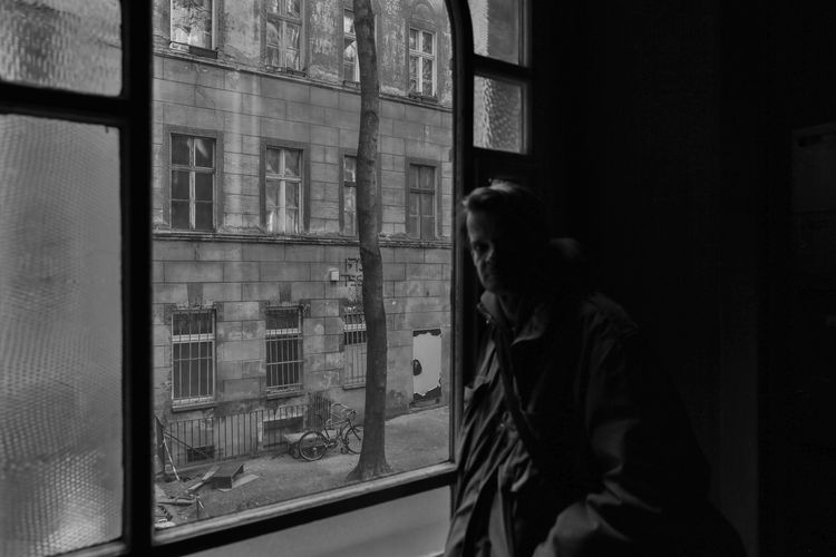 Portrait of mature man standing by window