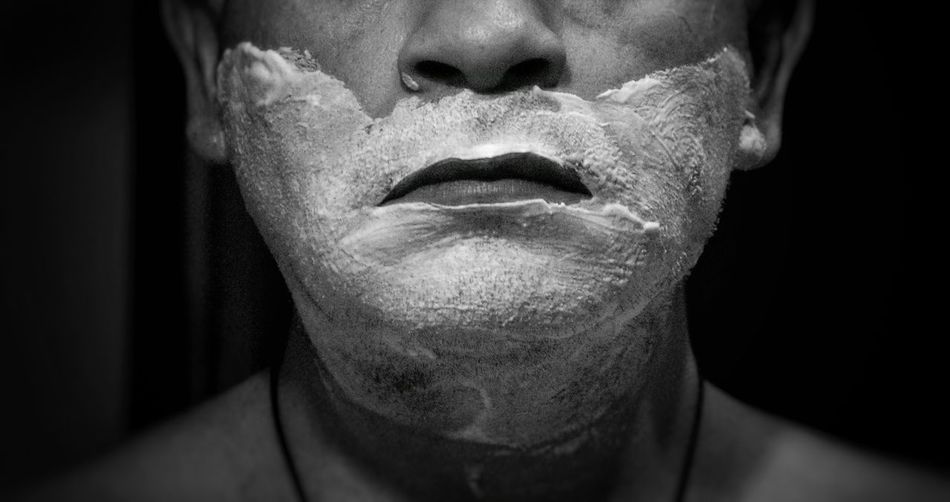 Midsection of man with shaving cream on face