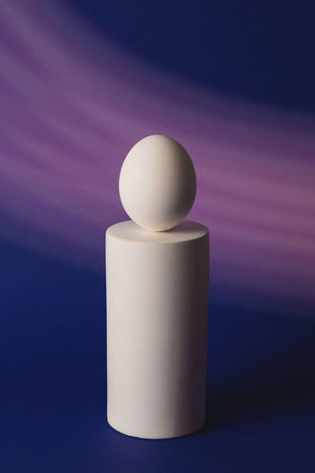 White easter egg on podium in neon and purple light