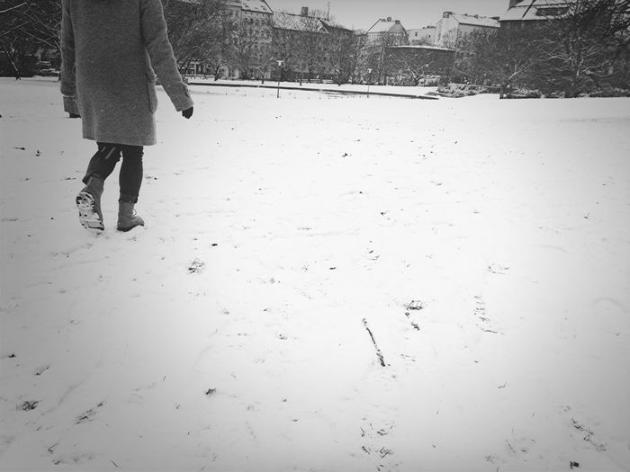 A young person walks alone in the snow