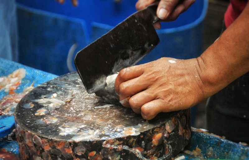 Close-up of man cutting fish at market