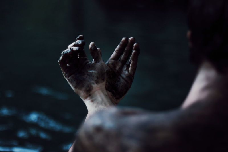 Close-up of man with dirty hands