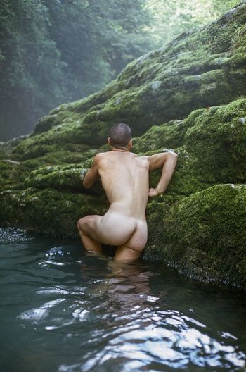 Shirtless man swimming in lake