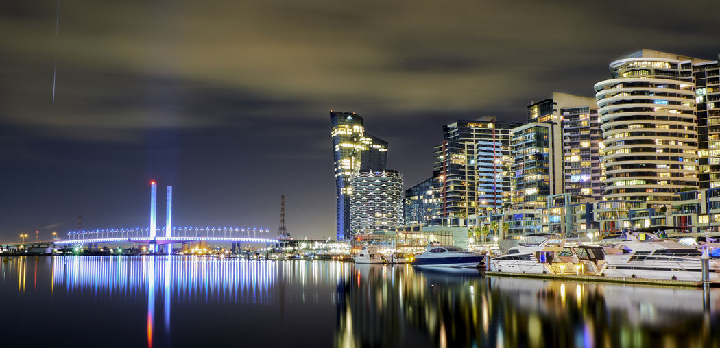 Illuminated buildings by river against sky at night. city scape of docklands melbourne australia 