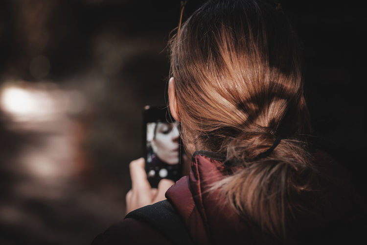 Rear view of woman photographing outdoors