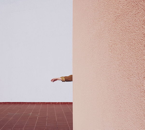 Cropped hand of child by wall