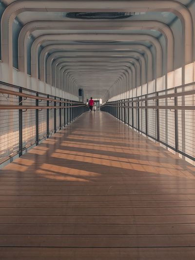 Silhouette man walking on footbridge