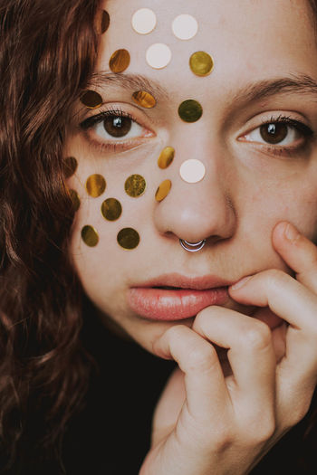 Close-up portrait of woman with polka dot on face