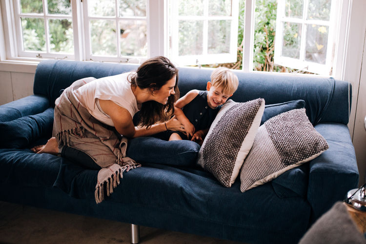 Cuddle Family Happiness Happy People Home Laughing Moments Mother Quality Time Bonding Boy Cabin Child Indoors Lifestyles Living Room Mom Positive Emotion Real People Relaxation Sitting Smile Sofa Toddler Togetherness