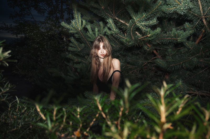 Young woman sitting amidst plants