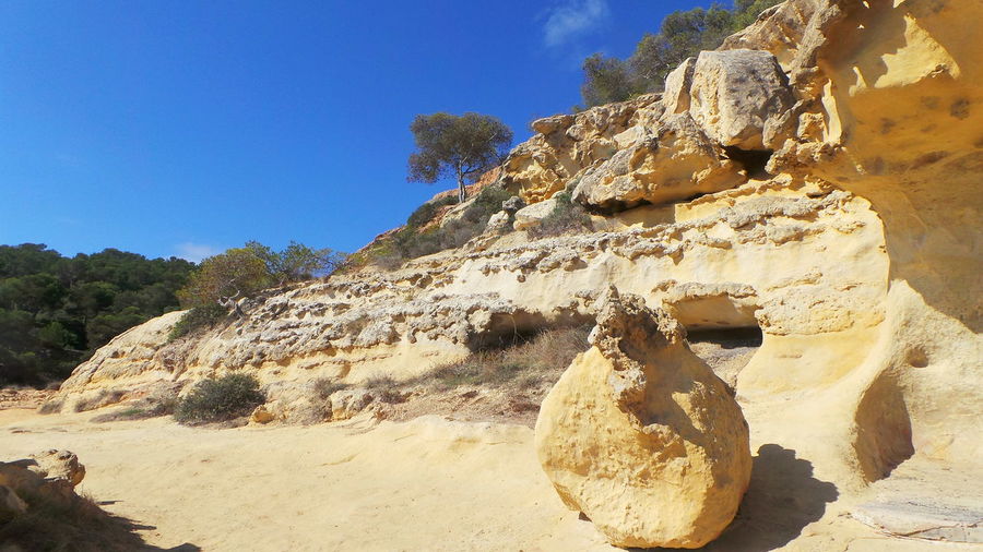 Rock formation on desert against sky