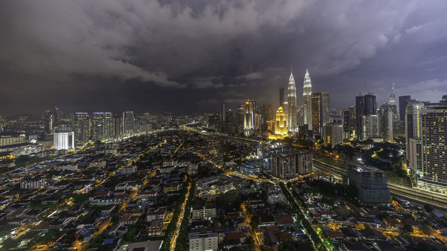 High angle view of illuminated buildings against sky in city