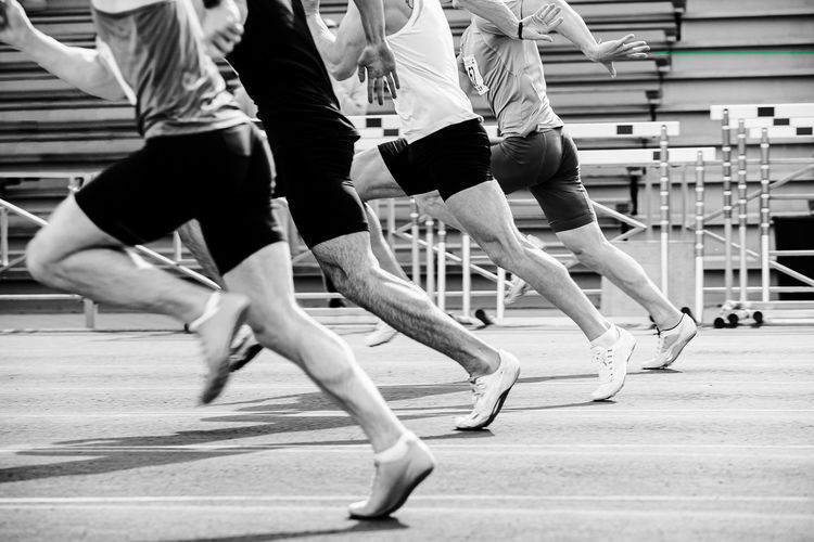 Run sprint race male athletes at stadium black and white photo