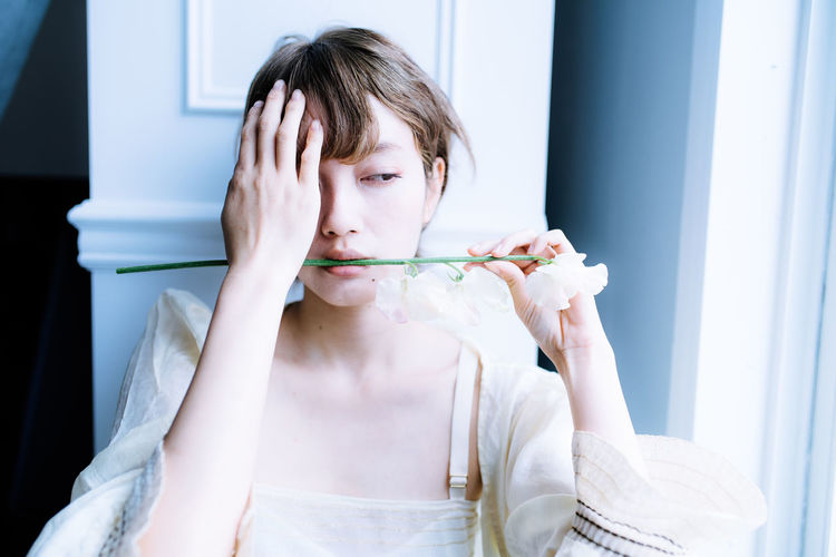 Woman holding flower amidst teeth