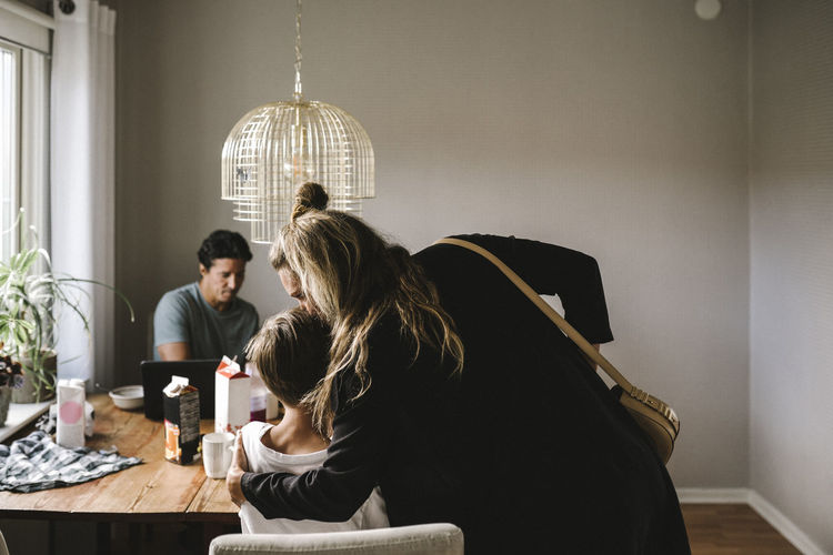 Mother kissing son over dining table at home